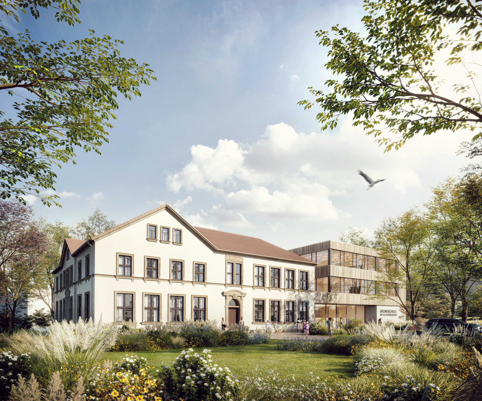 Eine Schule mit einem alten weißen Gebäude und einem modernen Holzanbau, umgeben von grünen Bäumen und bepflanzten Gärten unter blauem Himmel.